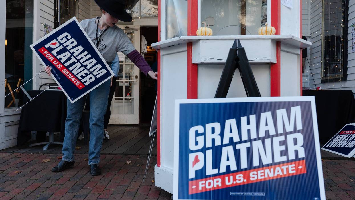 A Graham Platner volunteer holds a campaign sign