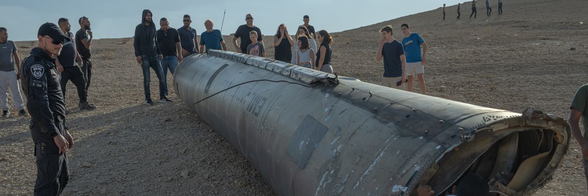 A group of people look at the remains of a missile on October 2, 2024 near the Dead Sea, Israel.