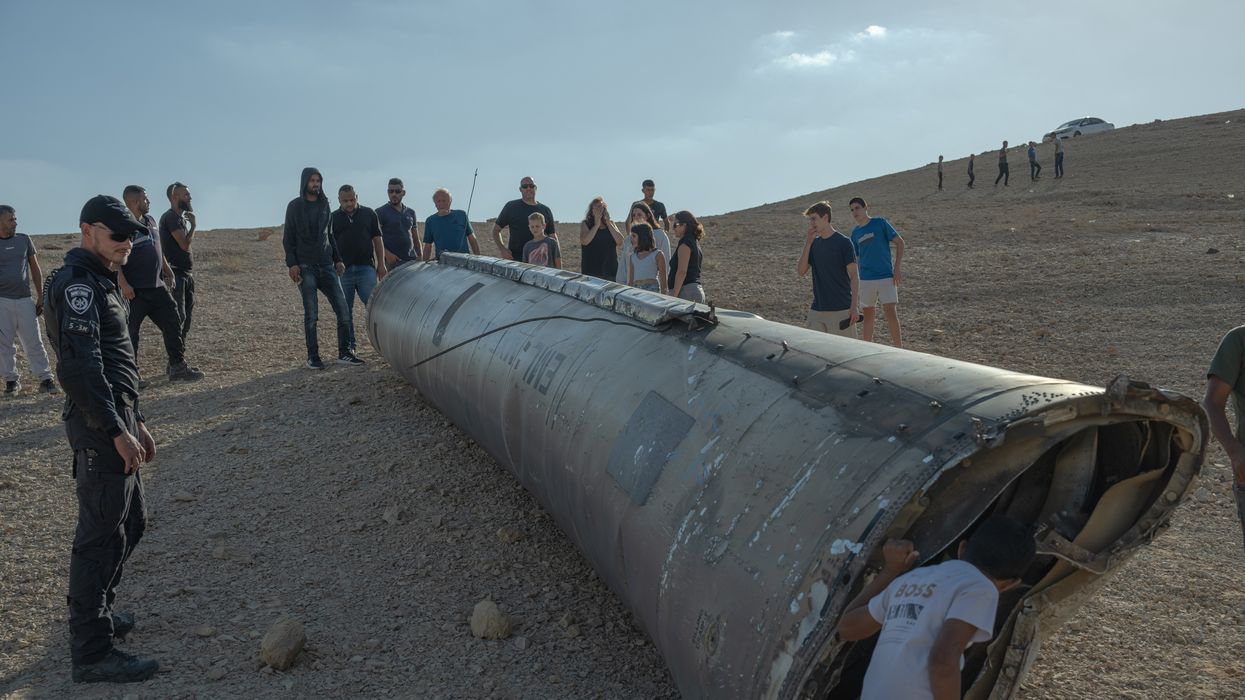 A group of people look at the remains of a missile on October 2, 2024 near the Dead Sea, Israel.