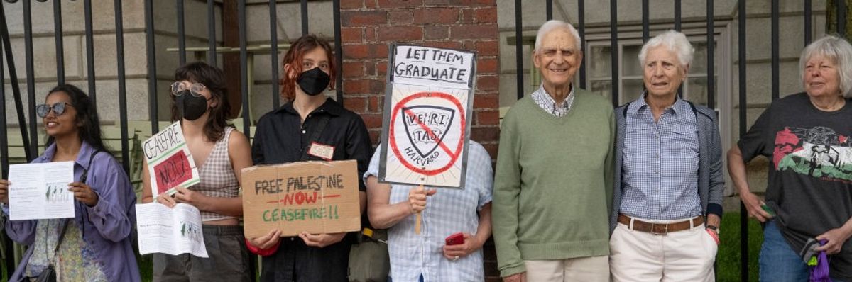 A group of protestors stand with placards