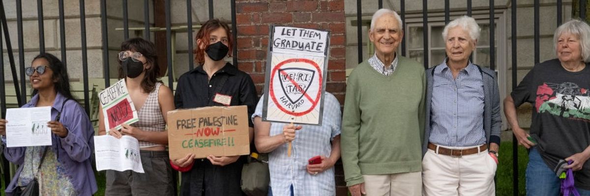 A group of protestors stand with placards