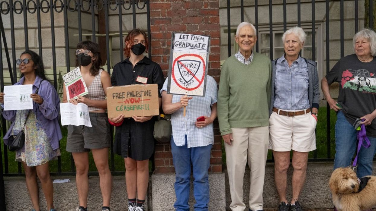 A group of protestors stand with placards