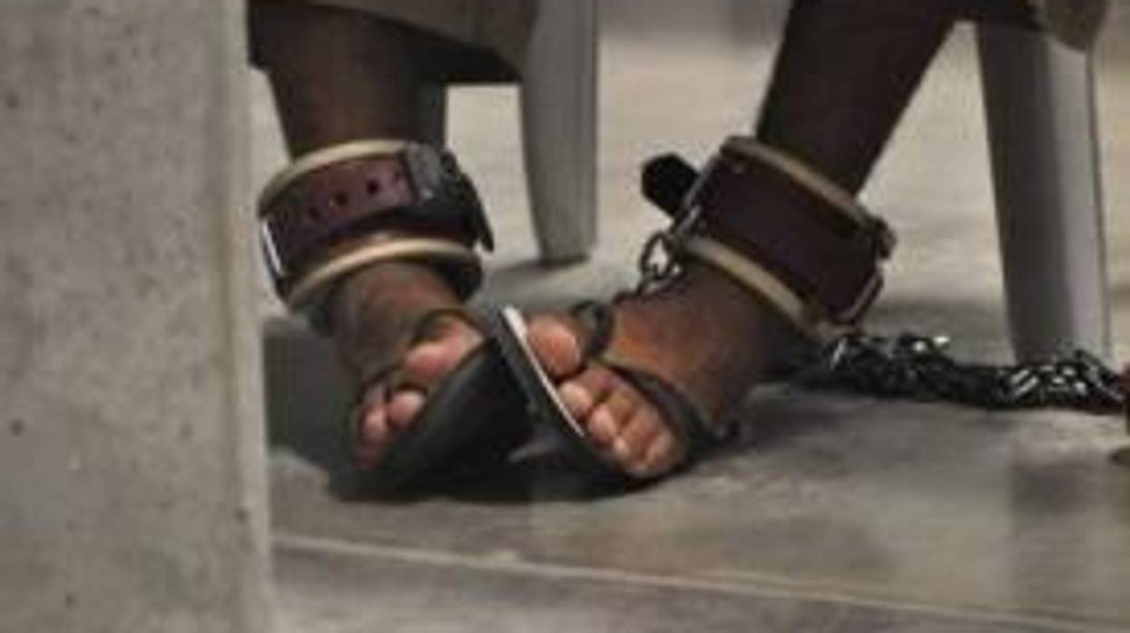 A Guantanamo detainee's feet are shackled to the floor
