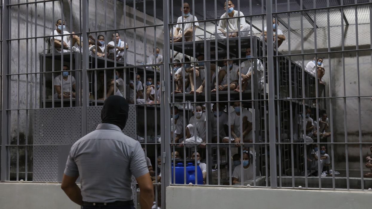 A guard stands outside a cell of prisoners at the Terrorism Confinement Center