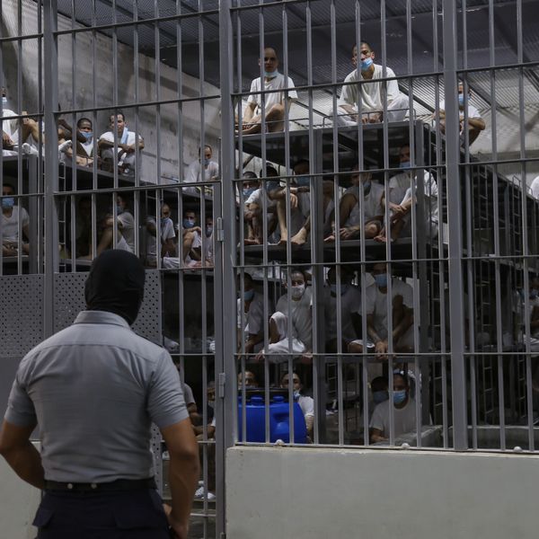 A guard stands outside a cell of prisoners at the Terrorism Confinement Center