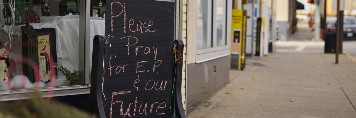 A handwritten sign is displayed outside a flower shop in East Palestine, Ohio.