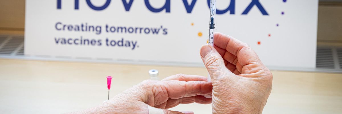 A health worker holds a Novavax vaccine