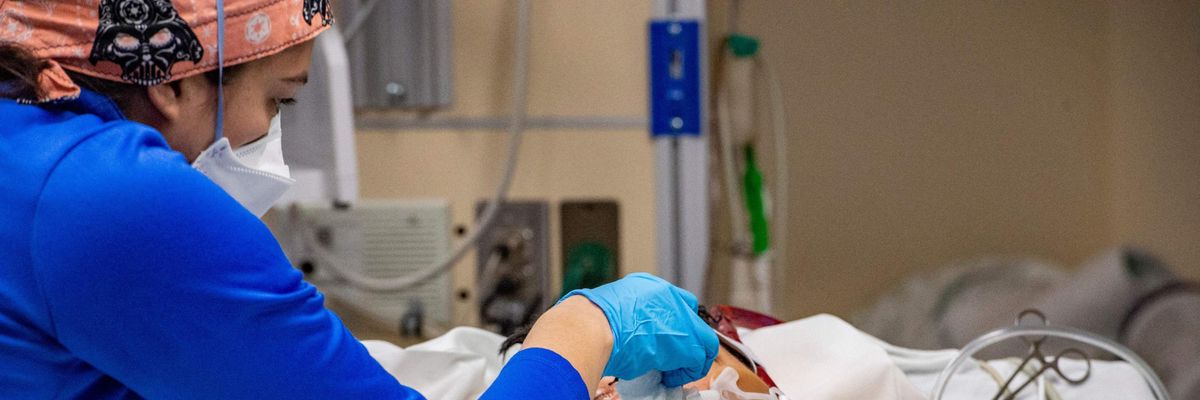 A healthcare worker assists a Covid-19 patient