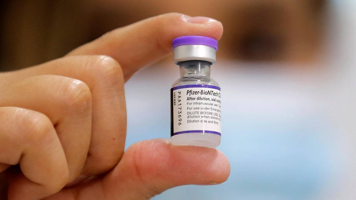 A healthcare worker holds up a vial of Pfize's Covid-19 vaccine