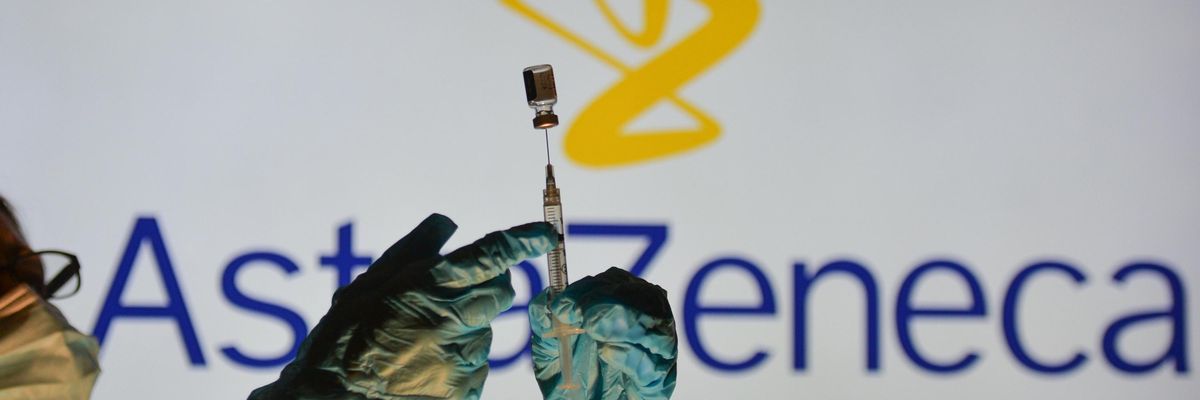 A healthcare worker holds up an AstraZeneca vaccine.