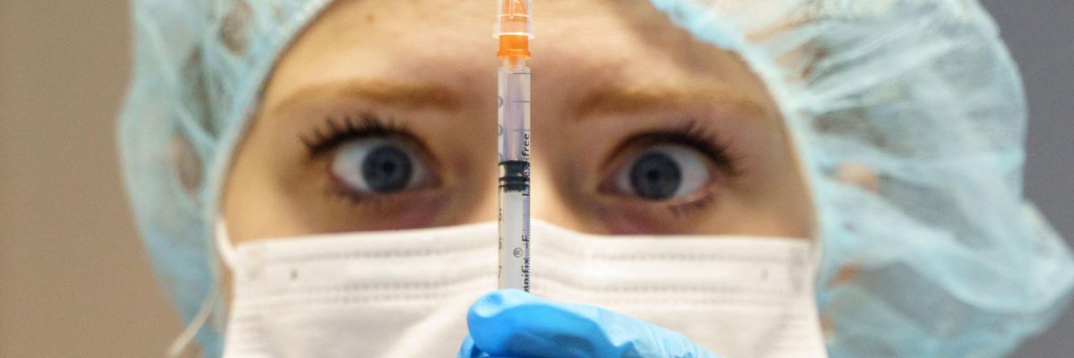 A healthcare worker with a syringe