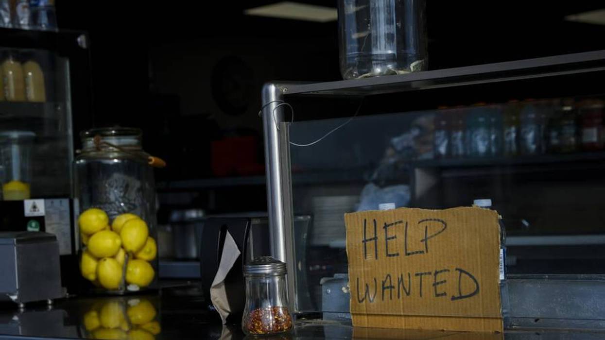 A "help wanted" sign is seen at a restaurant