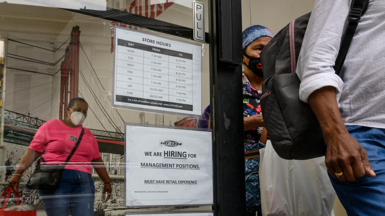 A hiring sign is displayed at a retail store in New York