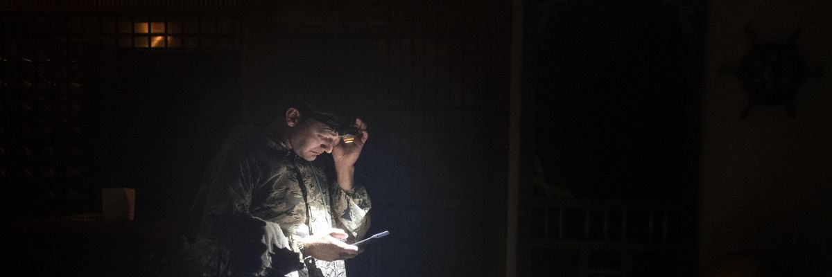 A hotel guest checks his smartphone in darkness due to a power outage