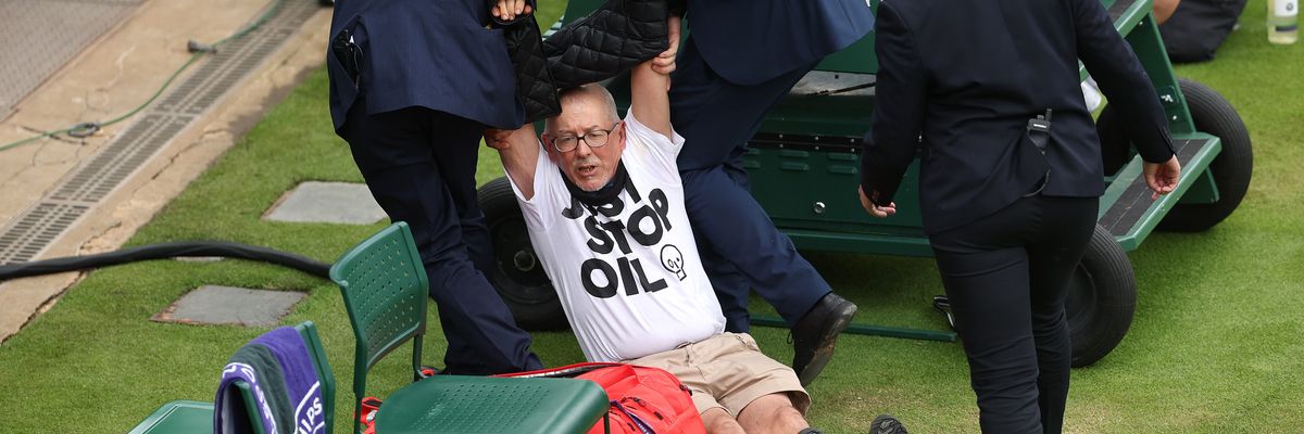 A Just Stop Oil protester is dragged off by security at Wimbledon