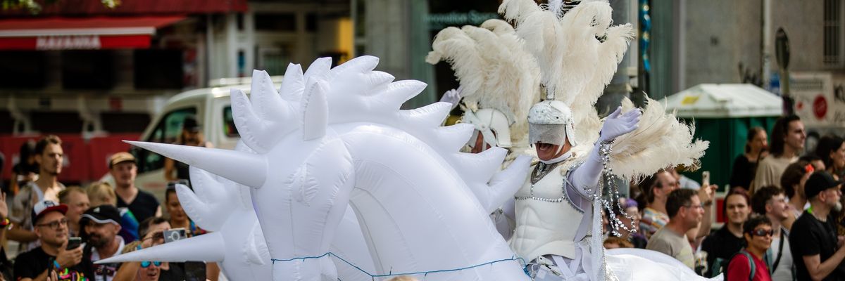 A knight in shining armor rides an inflatable unicorn in a Pride parade in Stuttgart