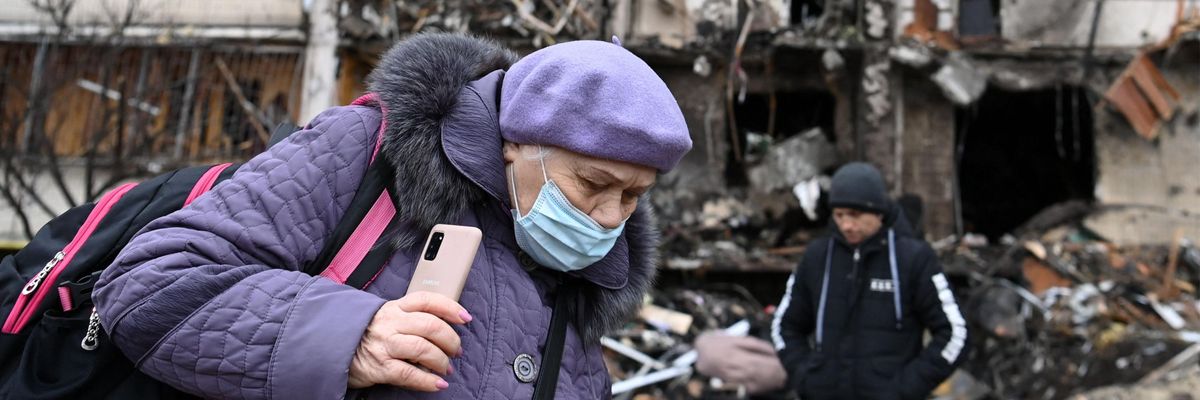 A Kyiv resident walks away from a damaged apartment building