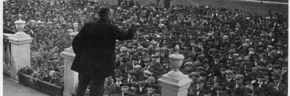 A labor leader speaks on s stage during a strike.