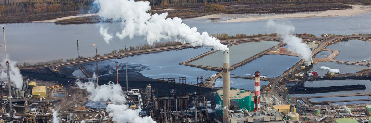 A large oil refinery is shown along the Athabasca River in Alberta, Canada.
