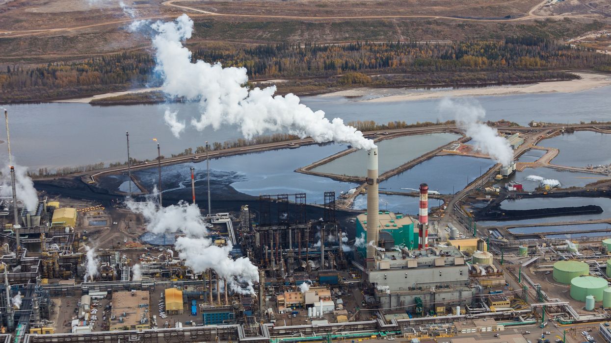 A large oil refinery is shown along the Athabasca River in Alberta, Canada.