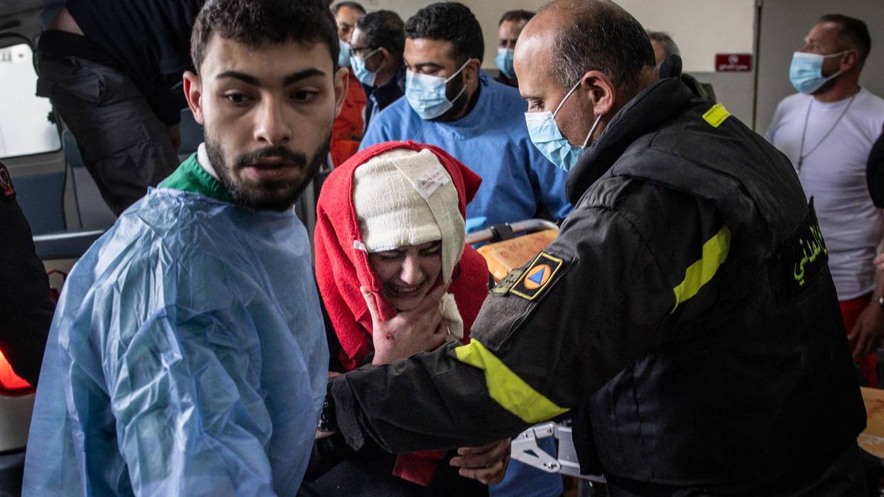 A Lebanese woman injured by an Israeli airstrike arrives in a hospital with her head bandaged