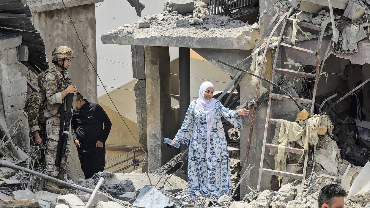 A Lebanese woman makes her way through rubble