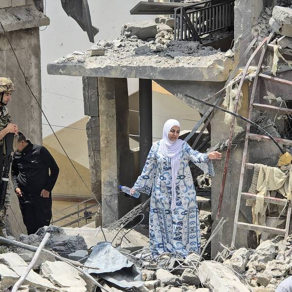 A Lebanese woman makes her way through rubble