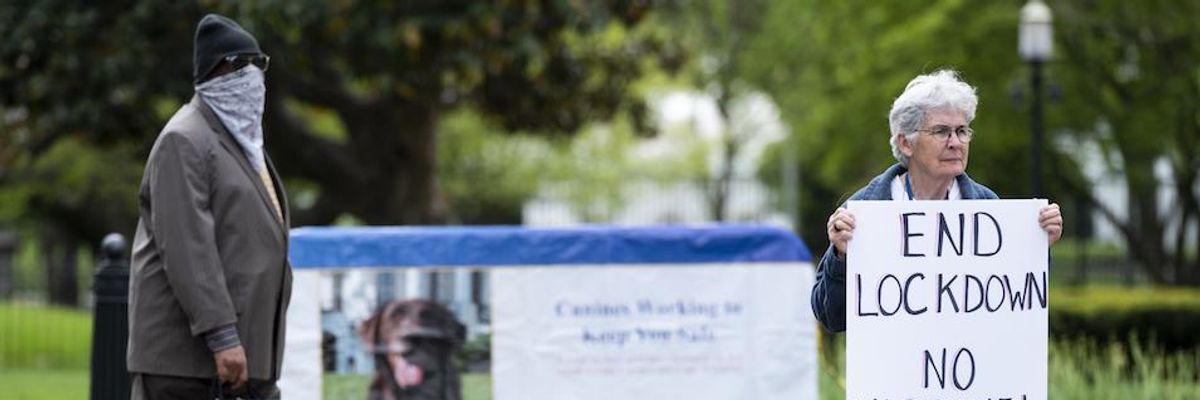 A lone protester holds a sign calling for an end to the lockdown and claiming chloroquine works as she stands in front of the White House in Washington on Saturday, April 25, 2020