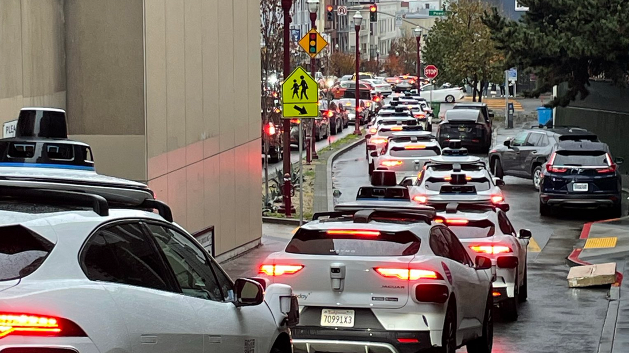 A long line of Waymo robotaxis snarls traffic in San Francisco