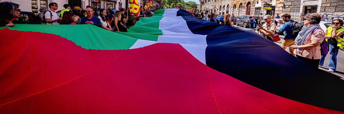 A long Palestinian flag is carried during a protest