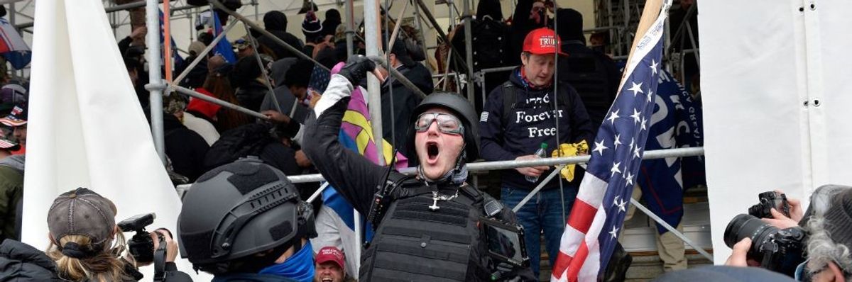 A man calls on people to raid the building as Trump supporters clash with police and security forces as they try to storm the US Capitol in Washington D.C on January 6, 2021.