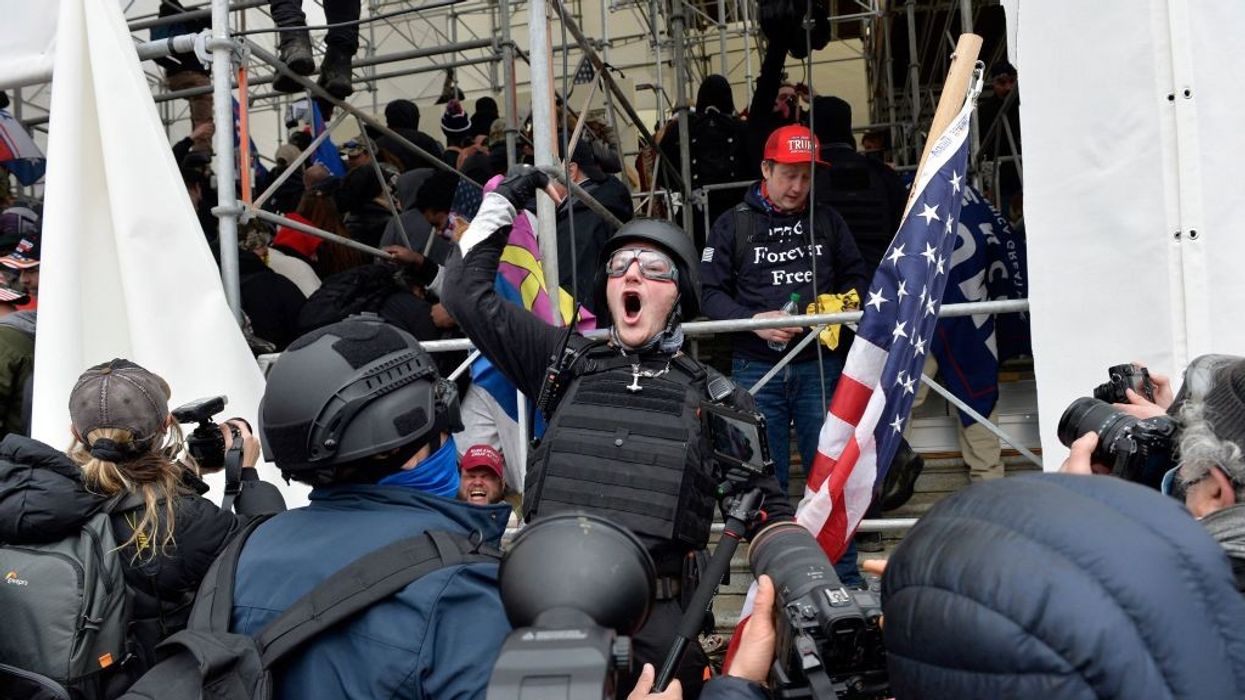 A man calls on people to raid the building as Trump supporters clash with police and security forces as they try to storm the US Capitol in Washington D.C on January 6, 2021.