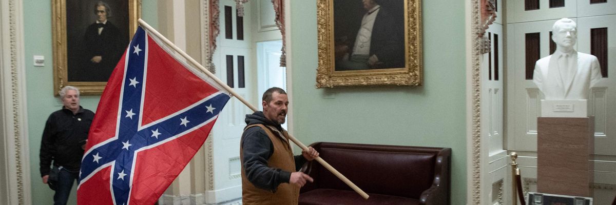 A man carries a Confederate flag in the Capital Rotunda.