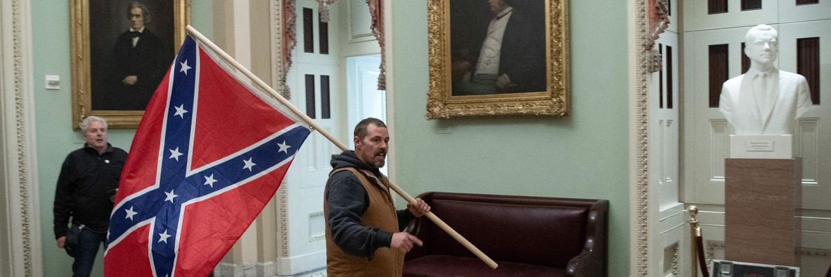A man carries a Confederate flag in the Capital Rotunda. 
