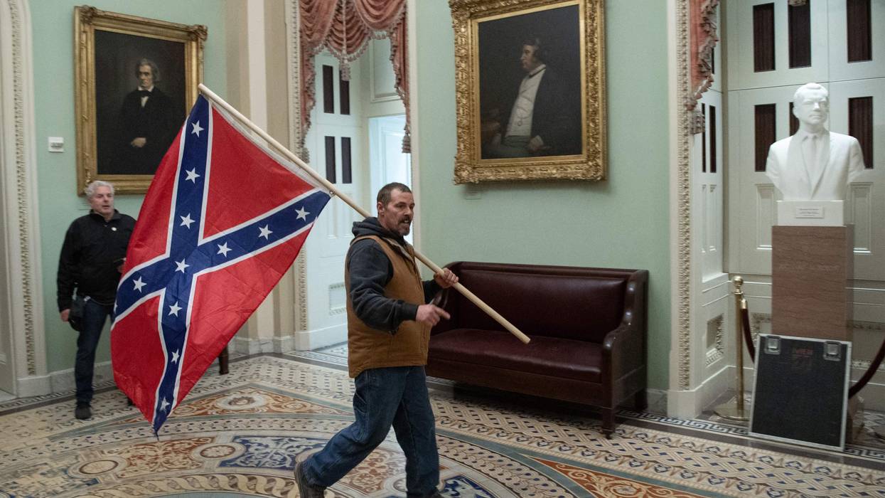 A man carries a Confederate flag in the Capital Rotunda.