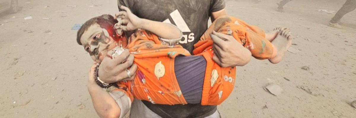 A man carries an injured Palestinian child after Israeli attack on Jabalia refugee camp in Gaza