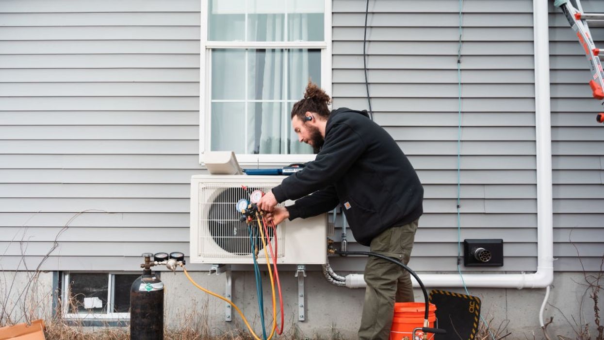 A man cleans moisture from a heat pump.