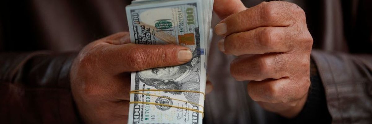 A man counts US dollar banknotes at al-Kifah stock market in Baghdad