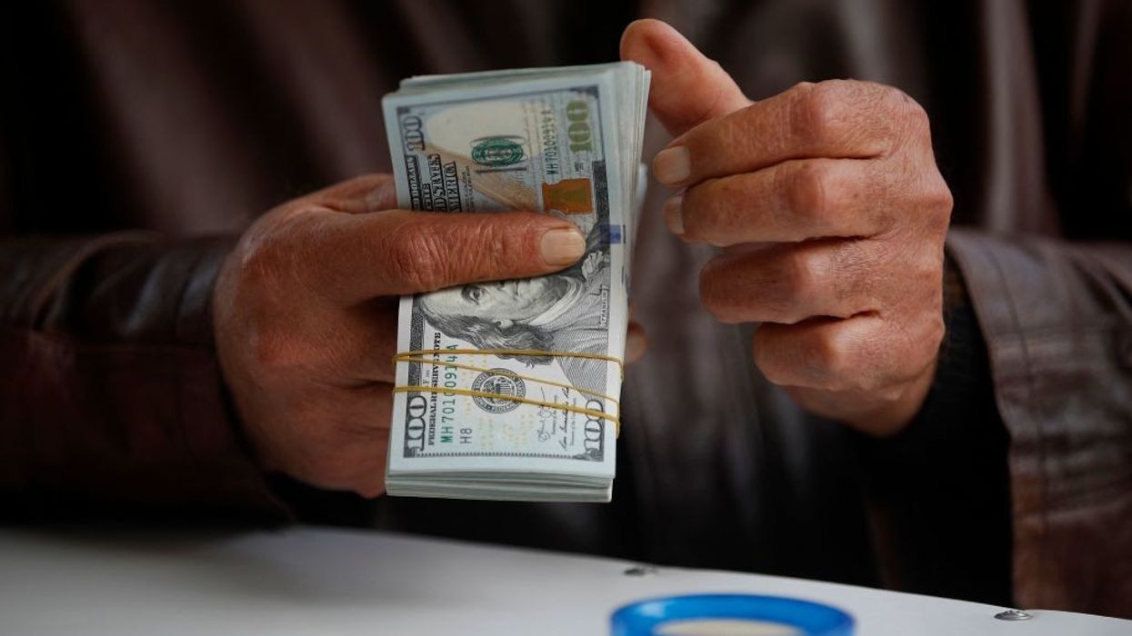 A man counts US dollar banknotes at al-Kifah stock market in Baghdad