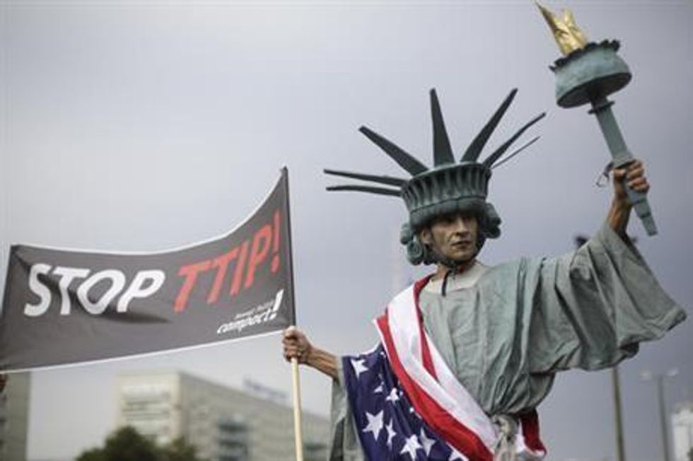 A man dressed like the Statue of Liberty attends a demonstration against the planned Transatlantic Trade and Investment Partnership, TTIP, and the Comprehensive Economic and Trade Agreement, CETA in Berlin, Saturday, Sept. 17, 2016. Thousands of people are rallying in cities across Germany to protest against planned European Union trade deals with the United States and Canada. (AP Photo/Markus Schreiber)