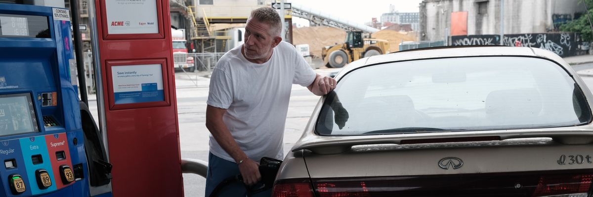 A man fills a car with gas.