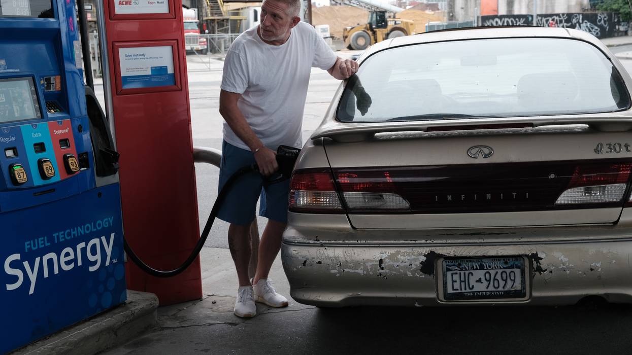 A man fills his car with gas.