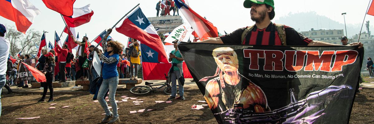 A man holds a flag with an image of former U.S. President Donald Trump during a demonstration against Chile's new draft constitution in Santiago on August 27, 2022.
