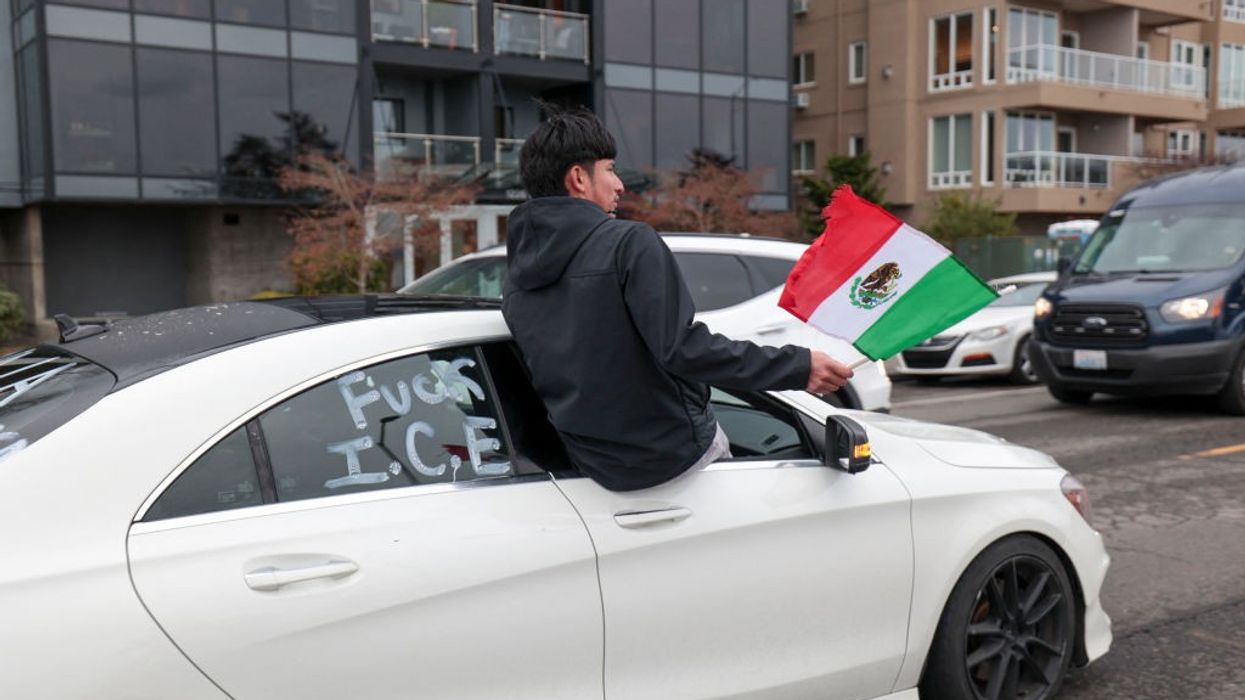 A man holds a Mexican flag during a protest against ICE