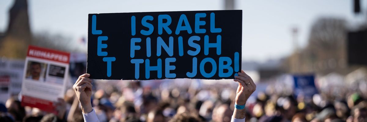 A man holds a sign reading "Let Israel Finish the Job" at the March for Israel rally in D.C.