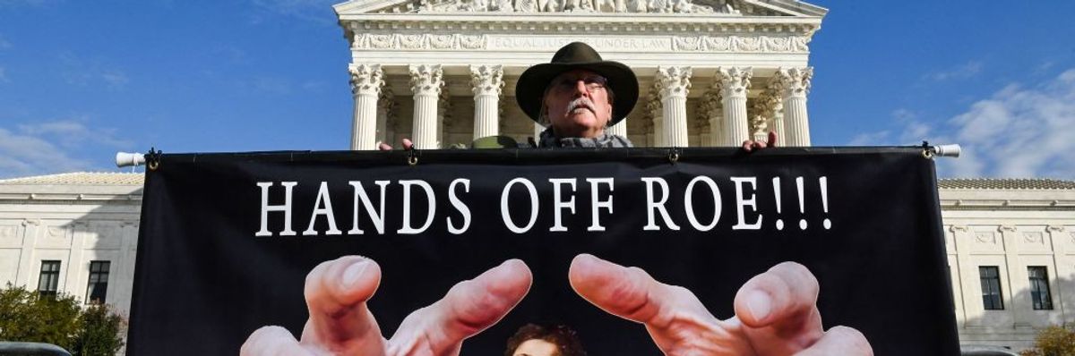A man holds a sign supporting Roe vs. Wade in front of the US Supreme Court