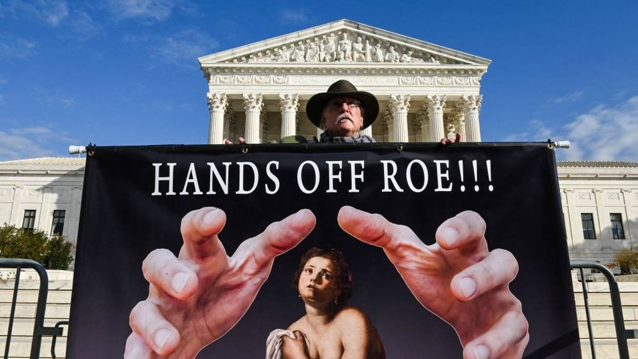 A man holds a sign supporting Roe vs. Wade in front of the US Supreme Court