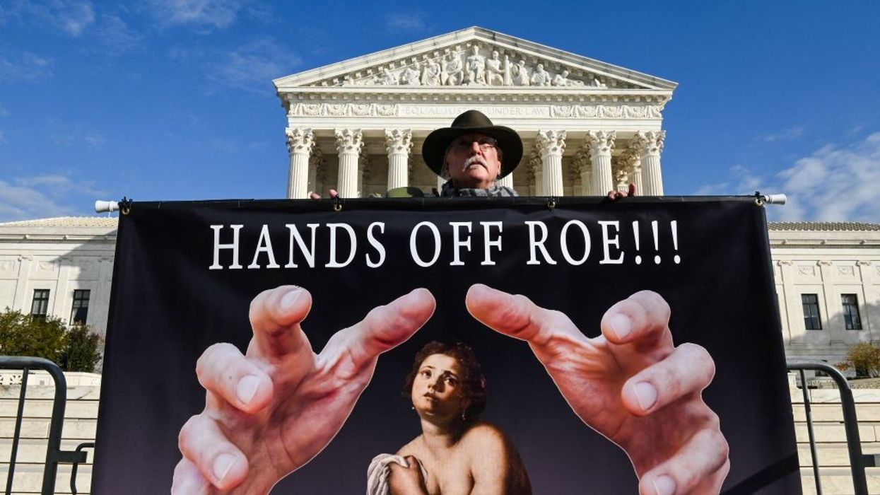 A man holds a sign supporting Roe vs. Wade in front of the US Supreme Court