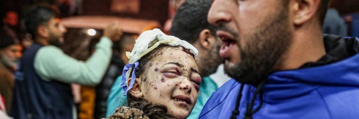 A man holds an injured child in a Gaza hospital.