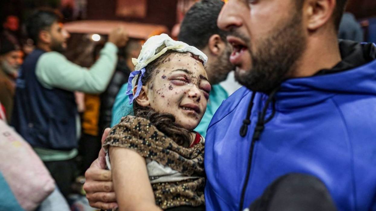 A man holds an injured child in a Gaza hospital.